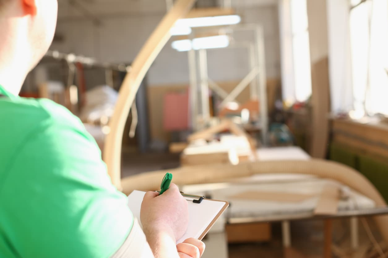 Inspector reviewing Hotel Furniture Quality Checklist Before Shipment at a factory loading bay