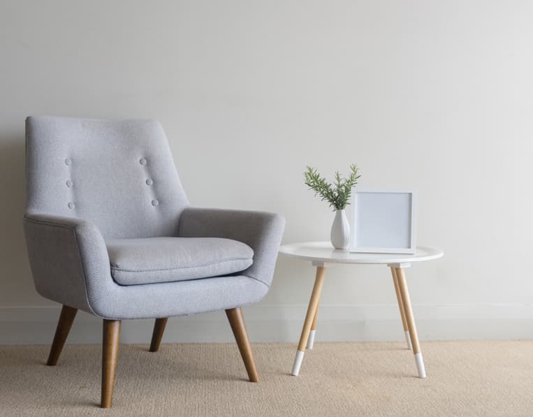 Minimal hotel accent chair with side table and soft neutral palette