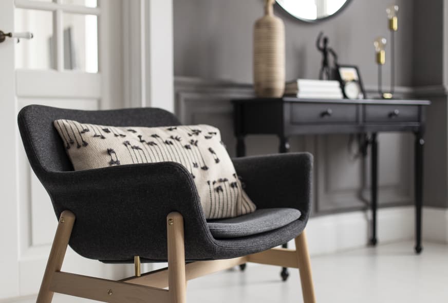 Modern accent armchair with wooden legs and upholstered seat for hotel suite or lounge area