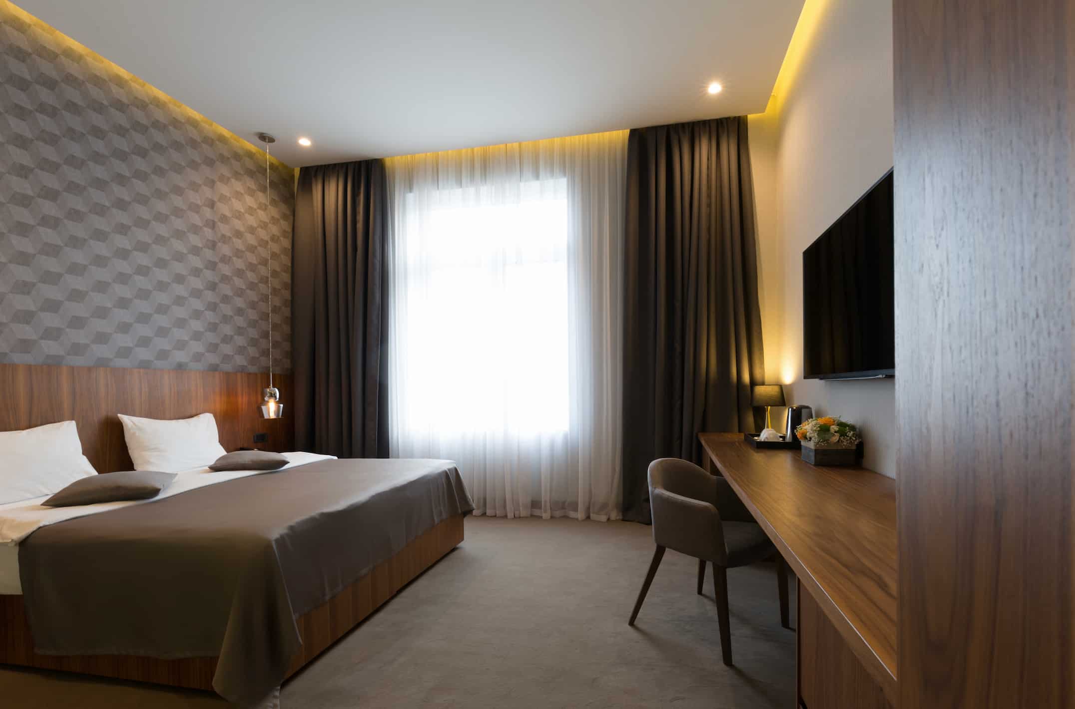 Guest room furniture manufacturer in Turkey showcasing modern hotel bedroom with bed, desk, TV unit and custom finishes.