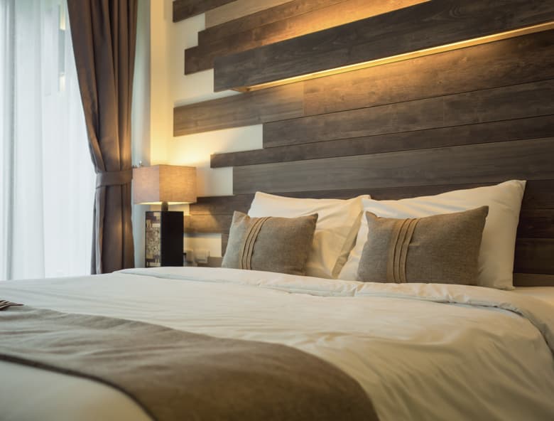 Modern hotel bedroom with wooden headboard, warm lighting, and neatly made bed in Ghana hotel project
