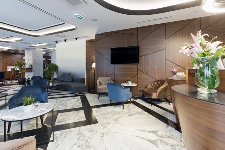 Modern hotel lobby seating area with wood wall panels, marble floor, and reception desk for Ghana hotel fit-out