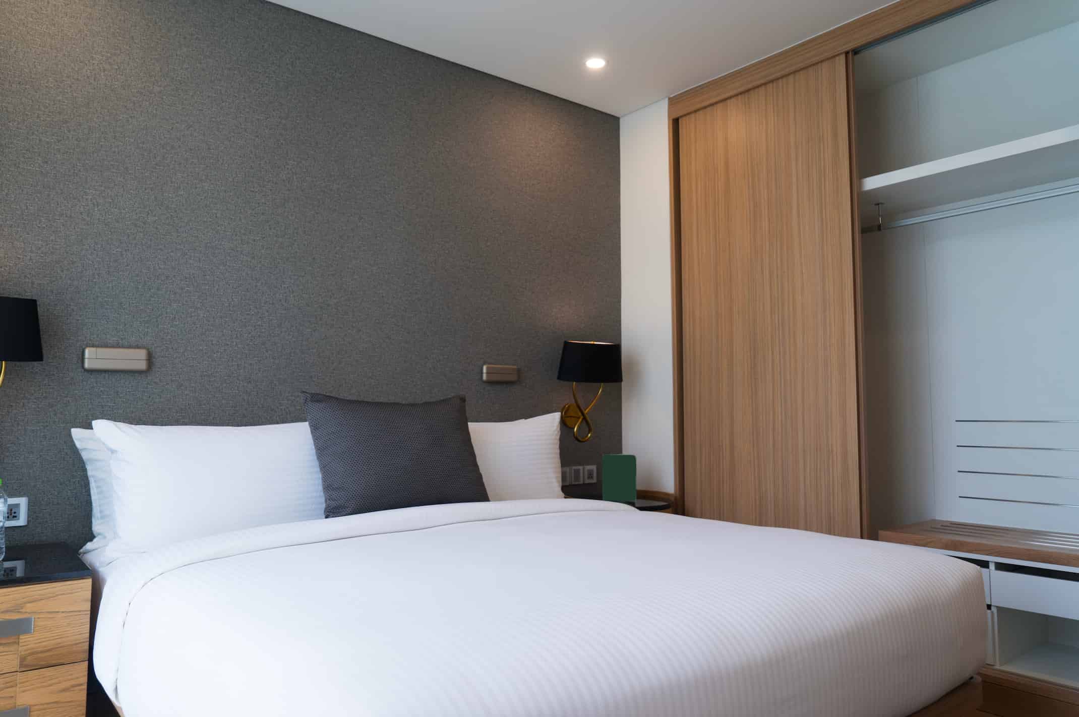 “Hotel wardrobe manufacturer in Turkey presenting sliding door hotel wardrobe with open shelving for modern guest rooms.