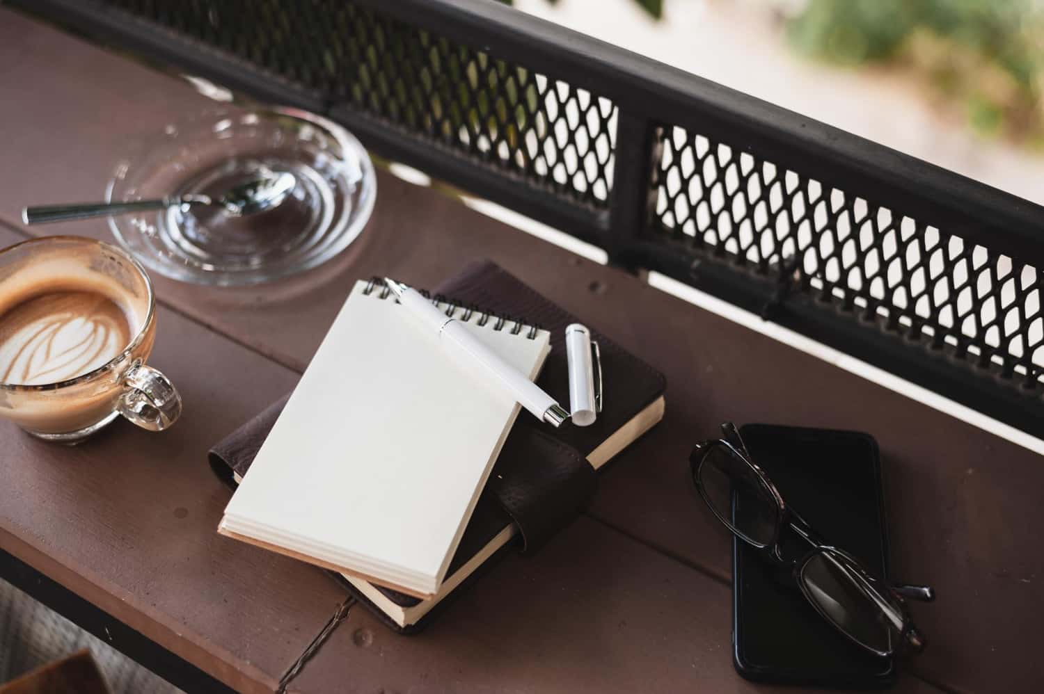 Hotel FF&E procurement planning — notebook and pen on contract furniture outdoor table for Ghana hotel project