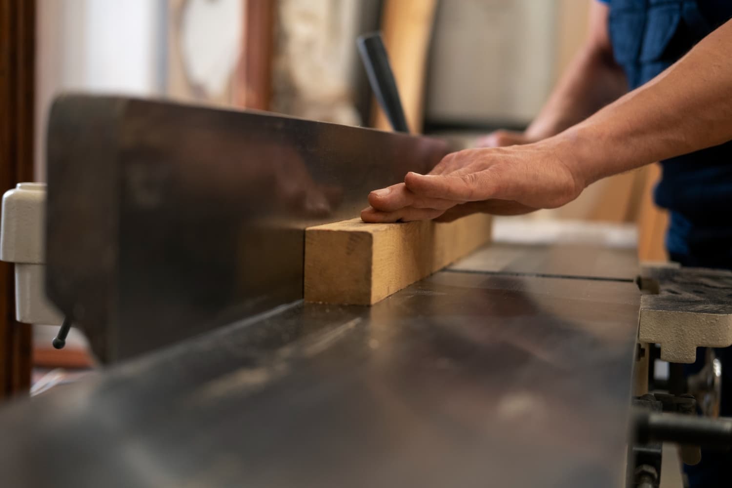 Hotel furniture supplier reviews Turkey — craftsman feeding solid wood through table saw on active production floor
